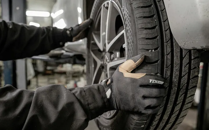 Gloved hands mounting a tire